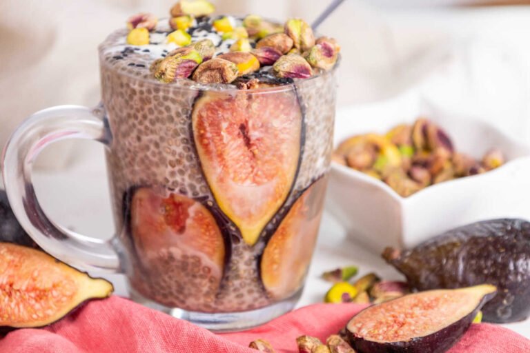 Chia pudding with figs topped with pistachios and black sesame in a glass jar